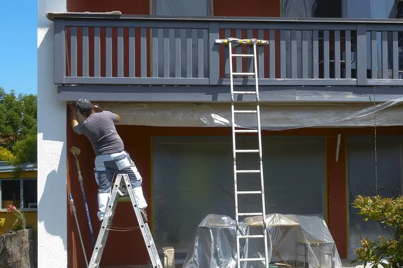 Exterior painting in Savannah: painter on a ladder painting house trim