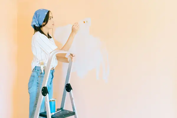 Interior painting in Savannah: painter on a stepladder rolling a wall
